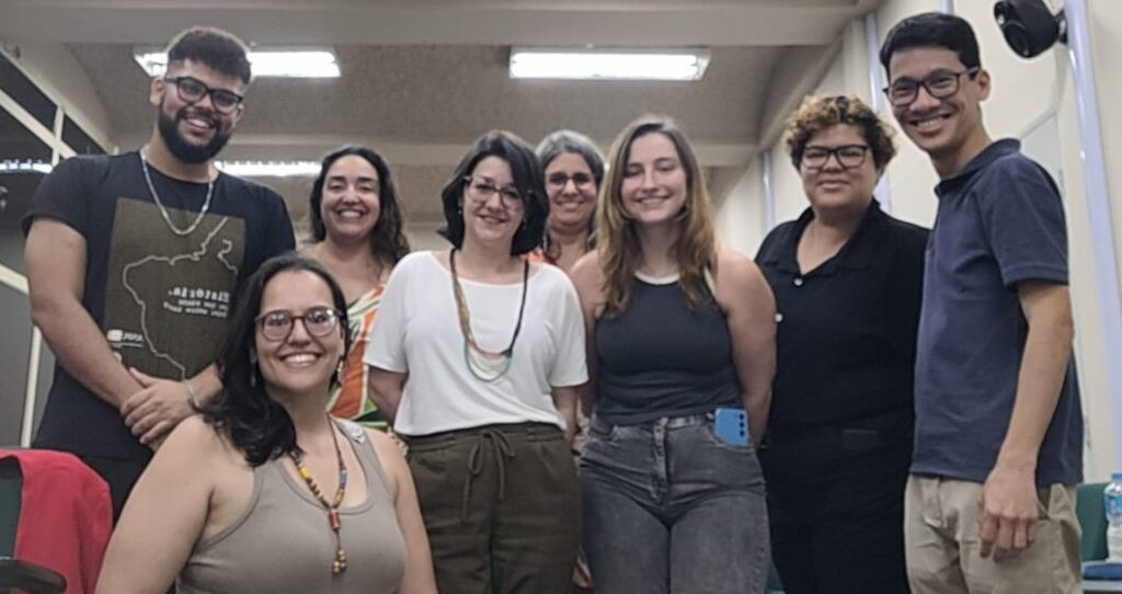 Participantes do ST 23 com a coordenadora Isabella Bonaventura (à esquerda, agachada, de regata cinza) e Henrique Sugahara Francisco (à direita, de camisa azul e calça bege).