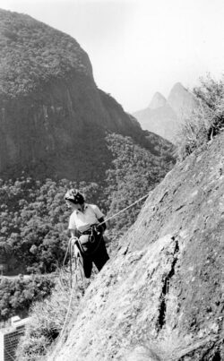 Foto antiga em Preto e Branco. Mulher escalando rocha com equipamento. Crédito: Casa de Oswaldo Cruz/Fiocruz